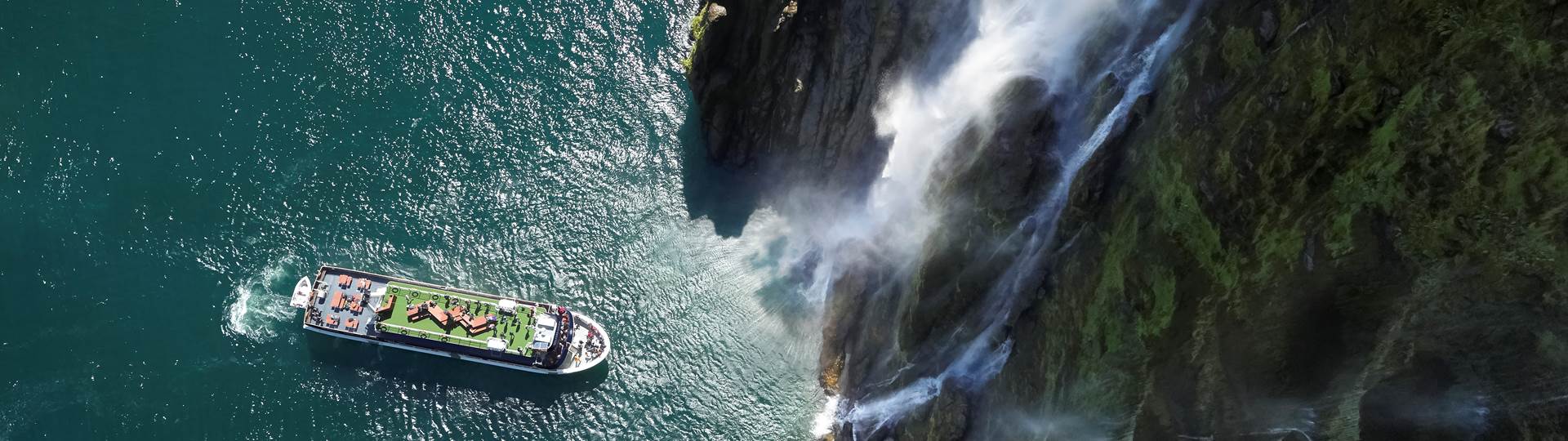 Cruising under the waterfalls in Milford Sound 